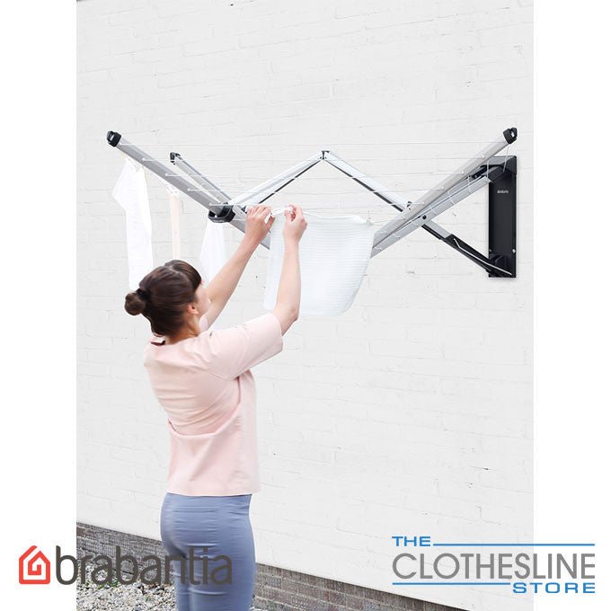 Brabantia WallFix 24m wall mounted clothesline with washing hanging outdoors.
