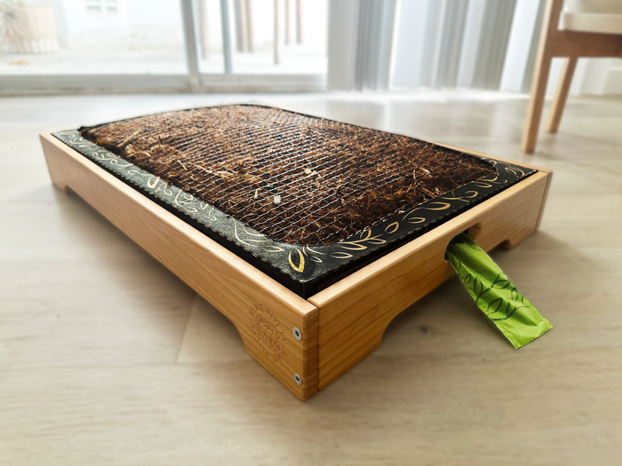 Wooden Bark Potty tray frame holding a disposable pet potty pad on a hardwood floor.