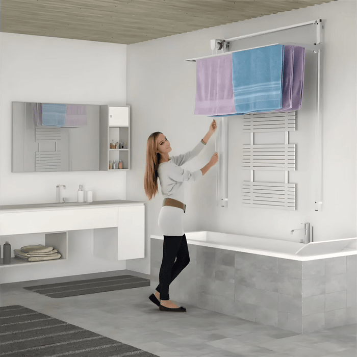 FoxyDry Wall height adjustable clothes airer installed above bathtub – space saving wall mounted drying rack for bathrooms.