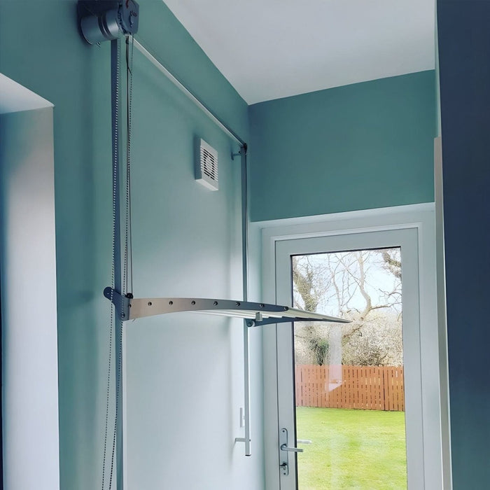 FoxyDry wall mounted clothes airer installed near a glass door showing a mid height and pulley system