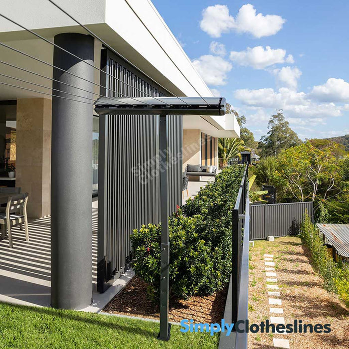 Hills Retractable 7 Line clothesline installed in a courtyard setting using a post mount kit for installation.