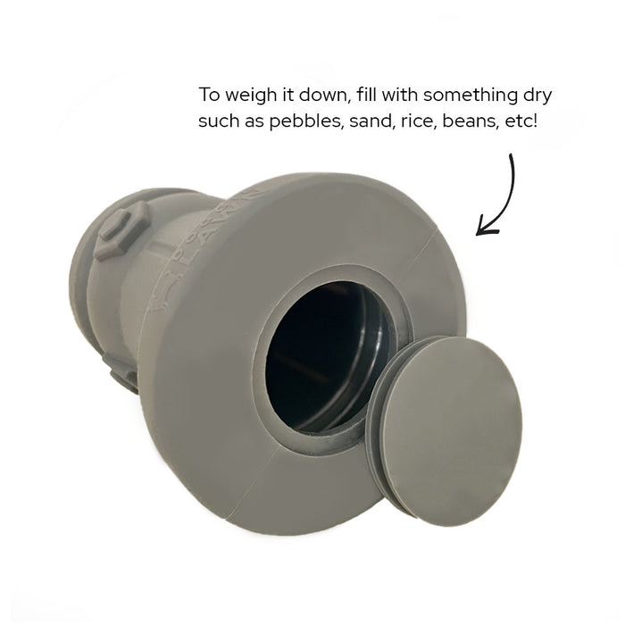 Gray silicone fire hydrant for dog potty training with bottom plug removed, showing hollow interior that can be filled with.