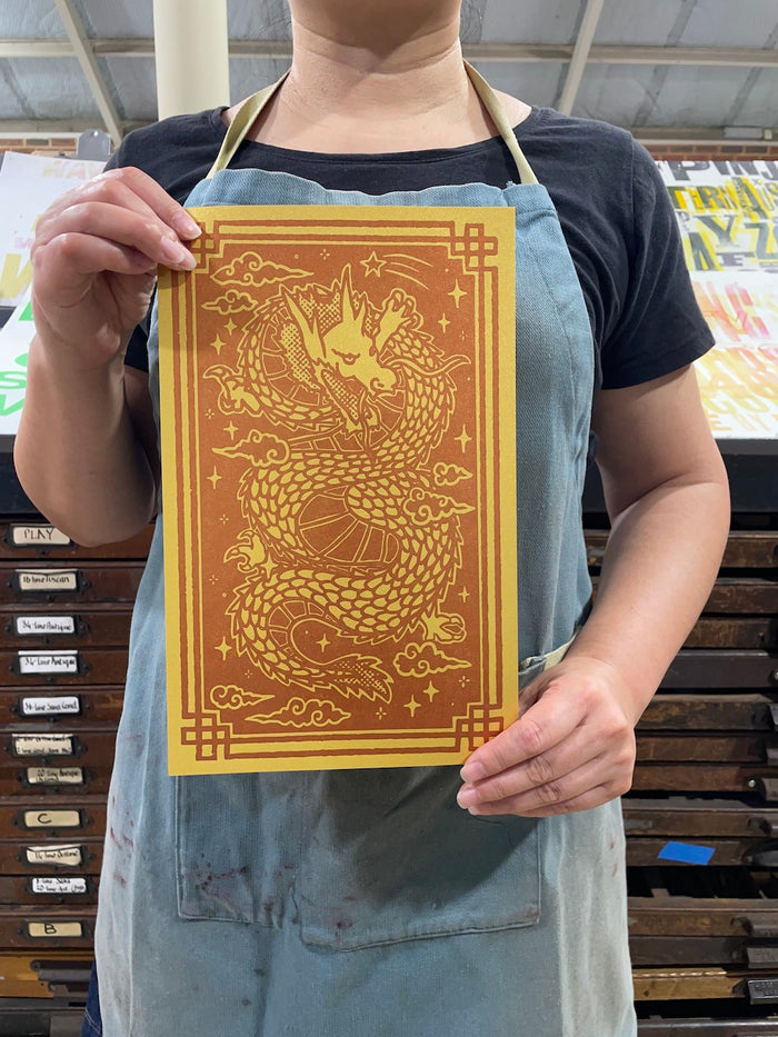 Ann's holding a Year of the Dragon print in the print shop.