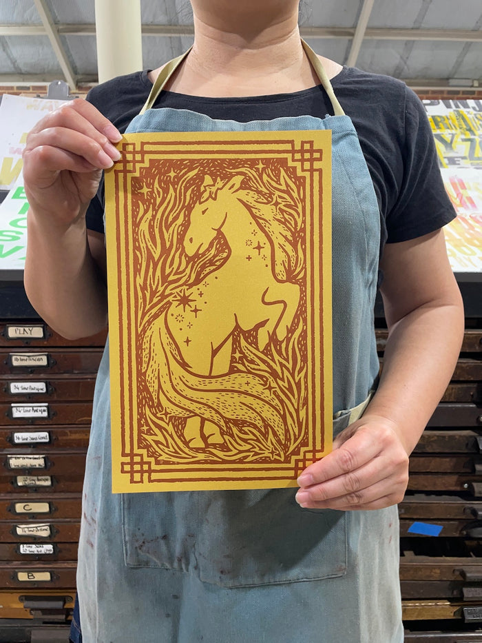 Ann is holding a Year of the Horse print in our print studio.