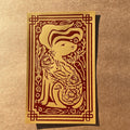 Year of the Rabbit print featuring a rabbit looking to the right with decorative cabbage on its body and carrots and foliage and a decorative border surrounding the rabbit on a brown textured background